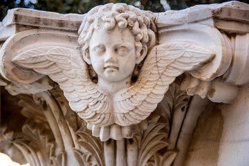 Statue of an angel on the facade of the ancient Greek temple.