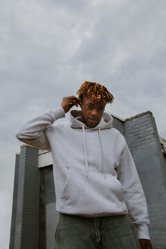 Confident young black man in casual clothes putting in ear pods