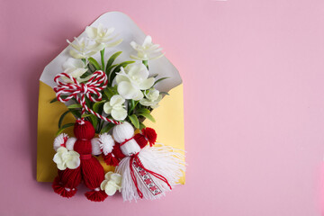 Martenitsa, Martisor with flowers in an envelope on a pink background flat lay copy space