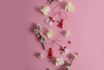 Martenitsa, Martisor among willow twigs and spring flowers on a pink background flat lay copy space