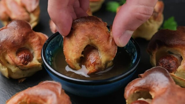 Dipping Mini Toad in the hole in gravy. Baked sausages in Yorkshire pudding