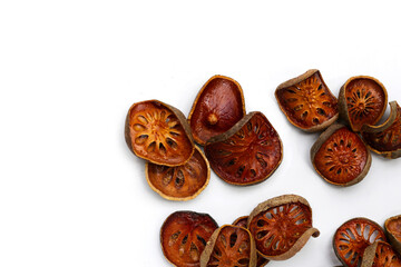 Dried bael fruit slices on white background.