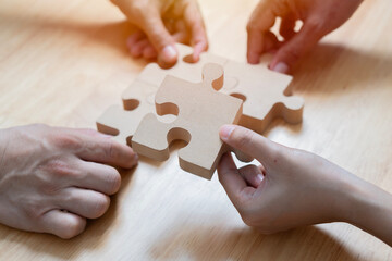 Closeup hand of woman connecting jigsaw puzzle with sunlight effect, Business solutions, success and strategy concept.