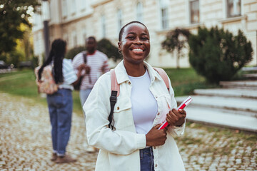 Smart female college student on campus outdoors. Female college student with books outdoors....
