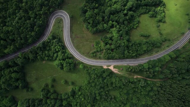 Aerial drone view of nature in Romania. Carpathian mountains, road, yellowed hill covered with forest