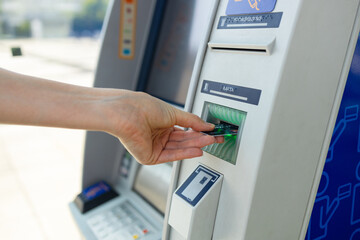Young woman using credit card and atm machine while withdrawing money. High quality photo