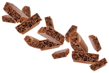 Levitation of cubes of milk porous chocolate isolated on a transparent background.