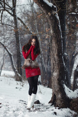 Portrait of pretty young oman in winter park.