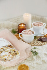 Aesthetic Christmas seasonal bread stollen - rich German fruit and nut loaf. Aesthetic table setting for two. Holiday season.