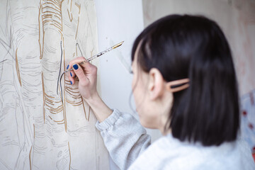 Female artist drawing painting with paint brush and black paint. Graphic Painting. Creating modern Art