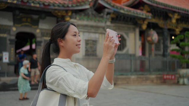 Woman use mobile phone to take photo in Chinese temple