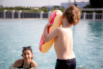 Caucasian family having enjoy and fun together with happiness in swimming pool, summer and holiday, mom and son relax and playful, summertime and vacation, relation and bonding, family concept.