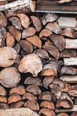 Rural full frame background with stack of firewood. Chopped wood stacked in pile. Preparation for cold winter. Heating the house with natural fuel.