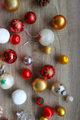 Pine cones and red, golden and white Christmas ornaments on wooden background. Top view.