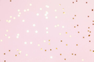 Gold sparkle confetti stars on a pink pastel background. Glitter, shine, bright. Christmas festive...