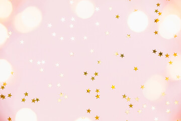 Christmas festive background. Gold party decorations, confetti stars, christmas lights on pastel...