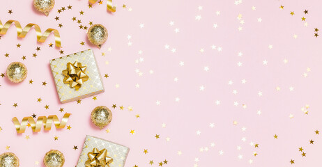Christmas composition flat lay. Gold party decorations, confetti, gifts on pastel pink background....