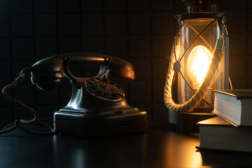 Vintage lamp and telephone. A study with rarities. A cozy atmospheric photo that transports us to another century - obrazy, fototapety, plakaty