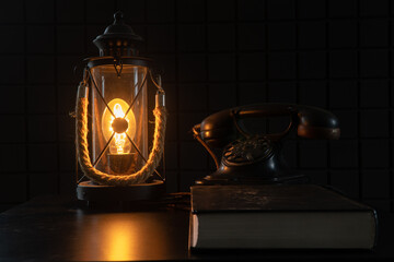 Vintage lamp and telephone. A study with rarities. A cozy atmospheric photo that transports us to another century