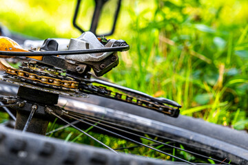 a bicycle thrown in the grass, focus on the chain