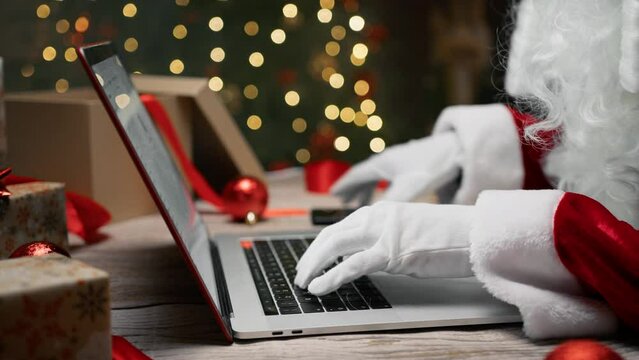 Santa Claus typing at Pc and scrolling smartphone 