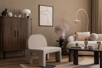 Warm and cozy composition of living room interior with mock up poster frame, boucle sofa, gray armchair, wooden sideboard, vase with dried flowers and personal accessories. Home decor. Template.