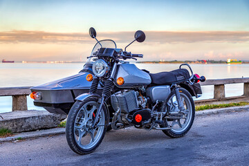 Recovered motorcycle with Sidecar parked near the sea. - obrazy, fototapety, plakaty