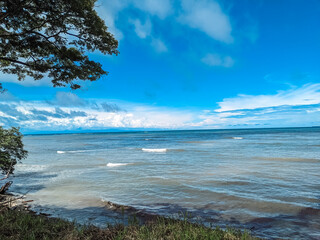 Costa Rican Beaches in the low season. sunny skies and blue waters with sea spray from the ocean. Beautiful setting.