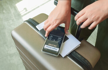 Traveler checking Flight status using flight tracker app on her smartphone. Selective focus.