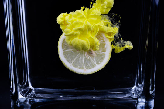 A lemon slice surrounded by a cloud of yellow acrylic paint 