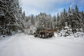 Winter mountain landscape with snowy extreme forest road and old truck with chains in the Carpathian mountains, outdoor travel and transportation background