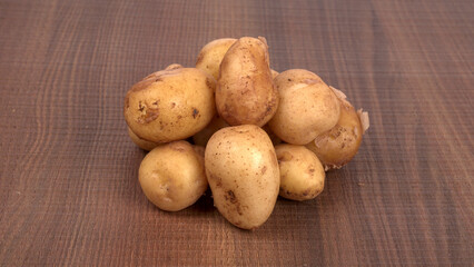 Fresh small potatoes for cooking in a wooden bowl. With copy space on white background.