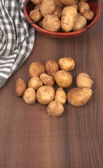 Fresh small potatoes for cooking in a wooden bowl. With copy space on white background.