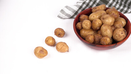 Fresh small potatoes for cooking in a wooden bowl. With copy space on white background.