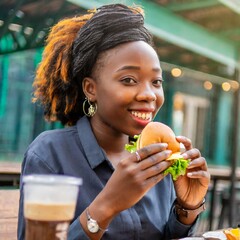 African woman enjoying a burger