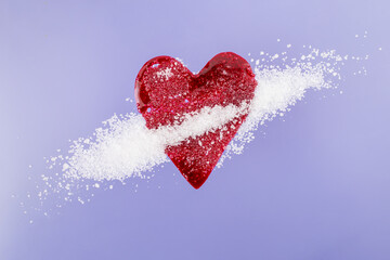 Red blood splatter in form of a heart mixed with sugar crystals on purple background, soft focus...