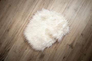 Fluffy fur nest on hardwood boards flooring with heavy vignette, flat lay new born photography backdrop