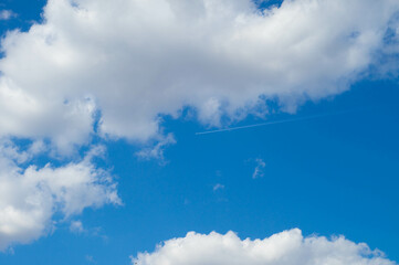 Blue sky with white clouds and airplane