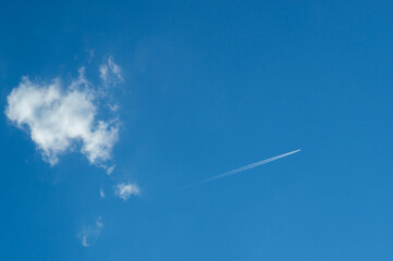 Blue sky with white clouds and airplane