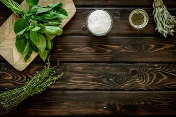 Cooking background with fresh green herbs on wooden board, top view - obrazy, fototapety, plakaty