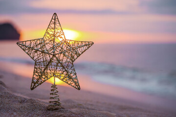 Golden christmas tree toy with big star on the beach