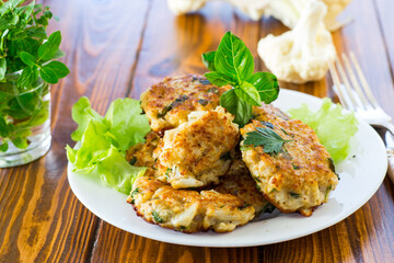 cooked vegetarian fried cauliflower cutlets, in a plate .