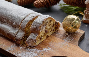 Christmas pastries stollen sprinkled with powdered sugar on the table, festive dessert