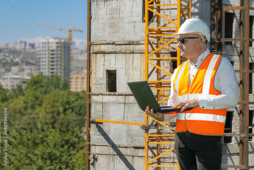 Aufkleber man builder with laptop. architect near building under construction. engineer at construction site. 