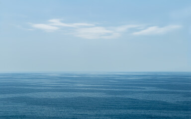 Fototapeta na wymiar Seascape with blue-toned waves. Calm sea, white clouds, blue sky. Mediterranean Sea. Catalonia, Spain.