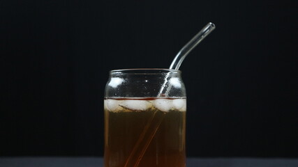 Glass of tasty Long Island iced tea on dark background with space for text