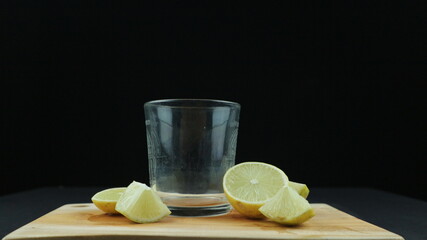 Fresh yellow lemon lime fruit with slices on wood cutting board on black background , Copy space