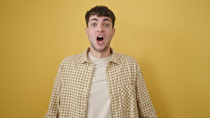 Obraz premium Young hispanic man standing with surprise expression over isolated yellow background