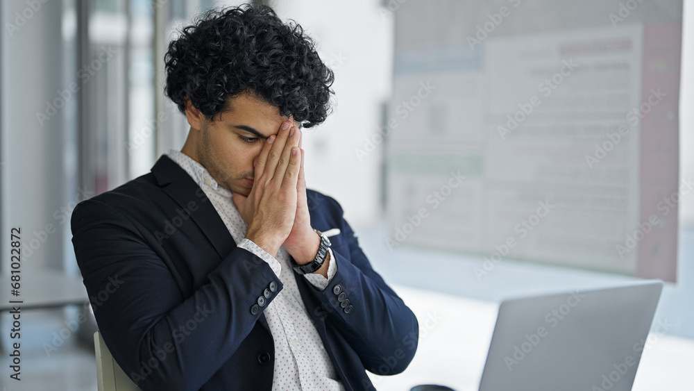 Poster Young latin man business worker using laptop stressed at office