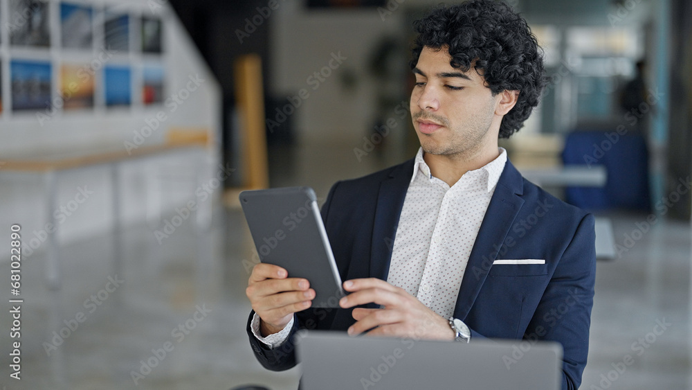 Poster Young latin man business worker using laptop and touchpad at office